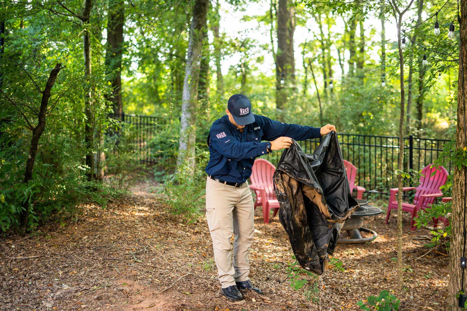 Vaco Pest Management Tech inspecting property for mosquito breeding spots.
